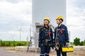 Asian man and woman Inspection engineers preparing and progress check of a wind turbine with safety in wind farm in Thailand Royalty Free Stock Photo