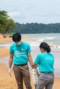 Khao Lak, Thailand, 1 june 2019: Asian man and woman picking plastic bottles into plastic bag black for cleaning the