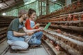 Asian man and woman workers use tablet together on farm