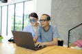 Asian man and woman working on computer laptop at home living room Royalty Free Stock Photo