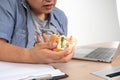 Asian man working and eating a burger on the office desk and heart attack. Concept of a busy businessman cannot work-left balance Royalty Free Stock Photo