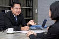 Asian manager in the black suit interviewed the applicant with a smile. The atmosphere of job interview in the modern office