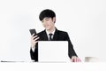 Asian manager businessman sitting at desk and using with phone Royalty Free Stock Photo