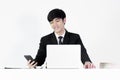 Asian manager businessman sitting at desk and using with phone, isolated on white background Royalty Free Stock Photo