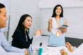 Asian mature business woman discussing and talking with other business people while sitting in meeting along with