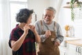 Asian mature senior couple is dancing and smiling in kitchen at home. Royalty Free Stock Photo