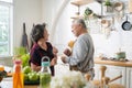 Asian mature senior couple is dancing and smiling in kitchen at home. Royalty Free Stock Photo