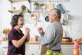 Asian mature senior couple is dancing and smiling in kitchen at home. Royalty Free Stock Photo