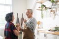 Asian mature senior couple is dancing and smiling in kitchen at home. Royalty Free Stock Photo