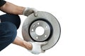 Asian mechanic holding a new brake disc on a white background