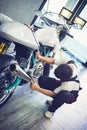 Asian mechanic man fixing the retro motorcycle in the garage. Film effected - Selective focused