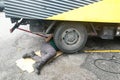 Asian mechanic under truck repairing dirty greasy engine with pr