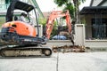 Asian mechanic using excavator in a small place