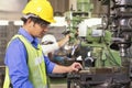 Asian mechanical engineer operating industrial lathe machine. Mechanical technician operative of machine in factory