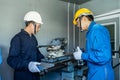 Asian mechanical workers working on milling machine. The technicians wearing protective glasses and helmet when operating the mach