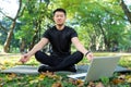 Asian meditating exercise in lotus pose, man resting after fitness Royalty Free Stock Photo