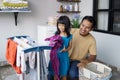 father householder and child daughter in laundry drying clothes