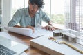 Asian men messy hair Speed up working architecture or Interior Designer study about building design with drawing paper, Building Royalty Free Stock Photo