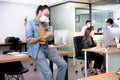 Asian man office worker wearing face mask working in new normal office and doing social distancing