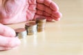 Asian men put hands to protect stack of growth money coin. Financial or saving plan for cost reduction, tax or retirement planning