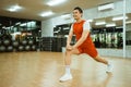 asian man in sportswear squatting to stretch his thigh muscles