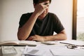 Asian men are stressed about financial problems, with invoices and calculators placed on the table while having stress on problems Royalty Free Stock Photo