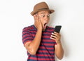 Asian men are using smartphones. He looks at the phone Then made a very surprised face. He is around 27-35 years old. He wears red Royalty Free Stock Photo