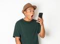 Asian men are using smartphones. He looks at the phone Then made a very surprised face He wears an old green shirt and wears a Royalty Free Stock Photo