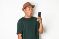 Asian men are using smartphones. He looks at the phone Then made a very surprised face He wears an old green shirt and wears a Royalty Free Stock Photo