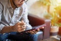 Asian men using tablet for woring at coffee care