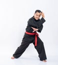 Asian men wearing pencak silat uniforms with red belts do dodging movements to the left