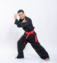 Asian men wearing pencak silat uniforms with red belts do dodging movements to the right