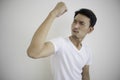 Asian men wearing white t-shirts Raising fist in right hand Showing signs of joy