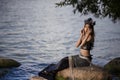 Asian Mermaid Caught In Net At Sea Coast on Rocks Wearing Seashell Decorated Crown and Black Shiny Tail On Body Covered With