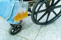 Asian middle-aged lady woman patient sitting on wheelchair with urine bag in the hospital ward Royalty Free Stock Photo