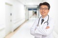 An Asian middle-aged male doctor smiling in the hospital corridor