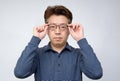 Asian middle-aged male trying to take off glasses and see something. poor sight, presbyopia, myopia.