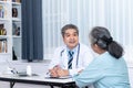 Asian middle-aged man doctor Talking, Explaining treatment procedures And health insurance plans For elderly women Royalty Free Stock Photo