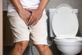 Asian middle aged man suffering from dysuria,acute cystitis, urinary tract infection,people patient holding crotch in toilet,