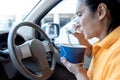 Asian middle-aged men eating food From paper cups While he was sitting in his own car