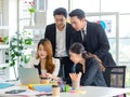 Asian millennial professional successful male businessman mentor in black formal suit standing helping two female employee sitting Royalty Free Stock Photo