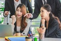 Asian millennial professional successful male businessman mentor in black formal suit standing helping two female employee sitting Royalty Free Stock Photo