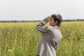 An Asian model poses in a field of yellow flowers for a clothing brand, polyethylene is the main props for a photo shoot Royalty Free Stock Photo