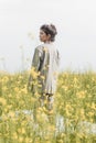 An Asian model poses in a field of yellow flowers for a clothing brand, polyethylene is the main props for a photo shoot