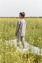 An Asian model poses in a field of yellow flowers for a clothing brand, polyethylene is the main props for a photo shoot Royalty Free Stock Photo