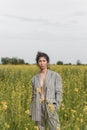 An Asian model poses in a field of yellow flowers for a clothing brand, polyethylene is the main props for a photo shoot Royalty Free Stock Photo