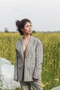 An Asian model poses in a field of yellow flowers for a clothing brand, polyethylene is the main props for a photo shoot