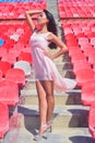 Asian model posing at the stadium sitting on bright seats