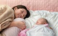 Asian mom and baby sleeping in bed, They smile together, Living lifestyle family indoors concept Royalty Free Stock Photo