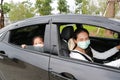 Asian mom and daughter wears hygiene face mask lying in car with looking through camera during coronavirus covid-19 outbreak